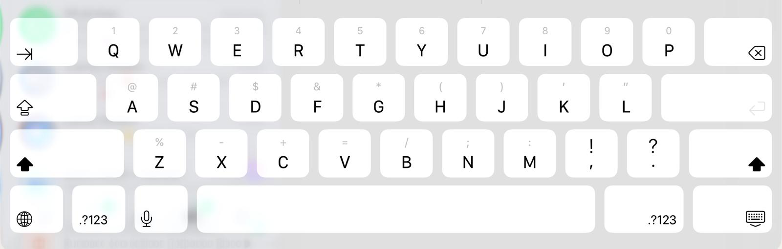 Apple's stock iPad keyboard in landscape, shifted to uppercase: a light grey background with near-white keycaps and dark grey letters, with faint grey secondary numbers and symbols above each key.