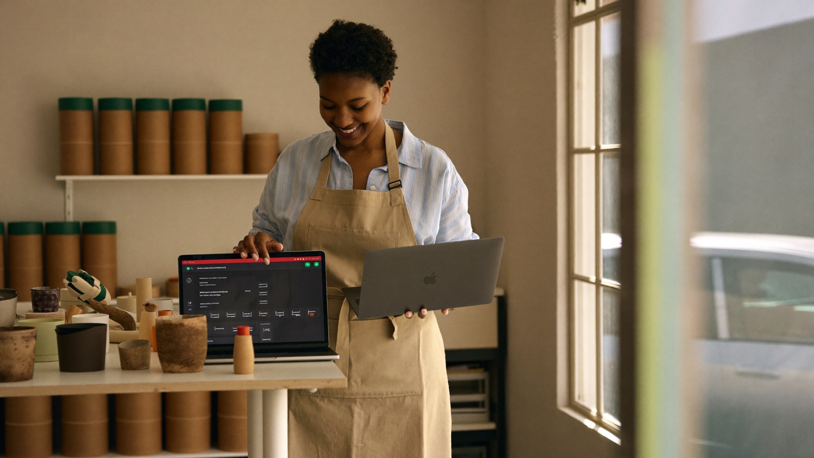 A small-business owner reviews an automated task dashboard on a laptop in her workshop