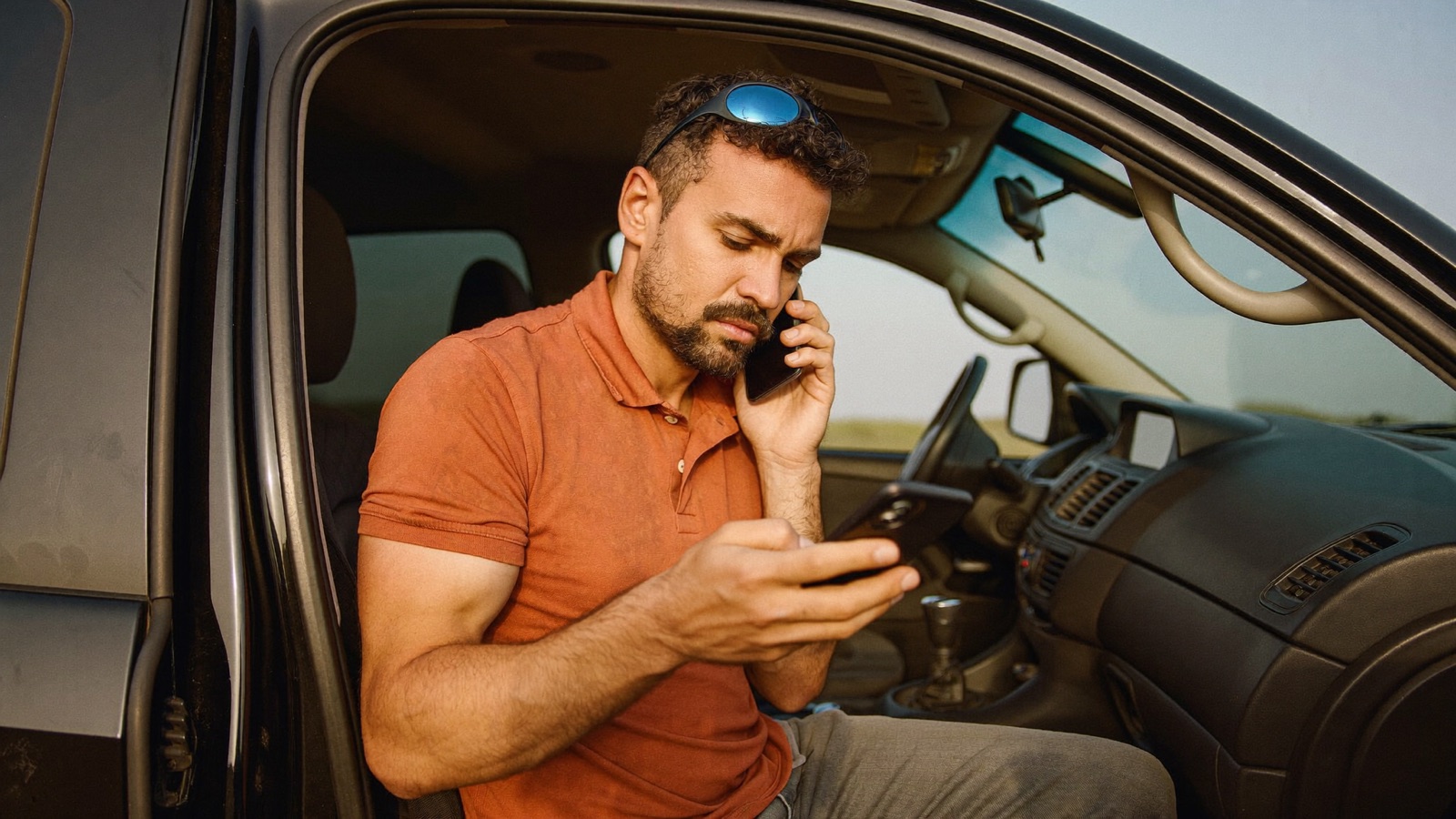 A contractor quickly replies to a customer message from the door of his work van